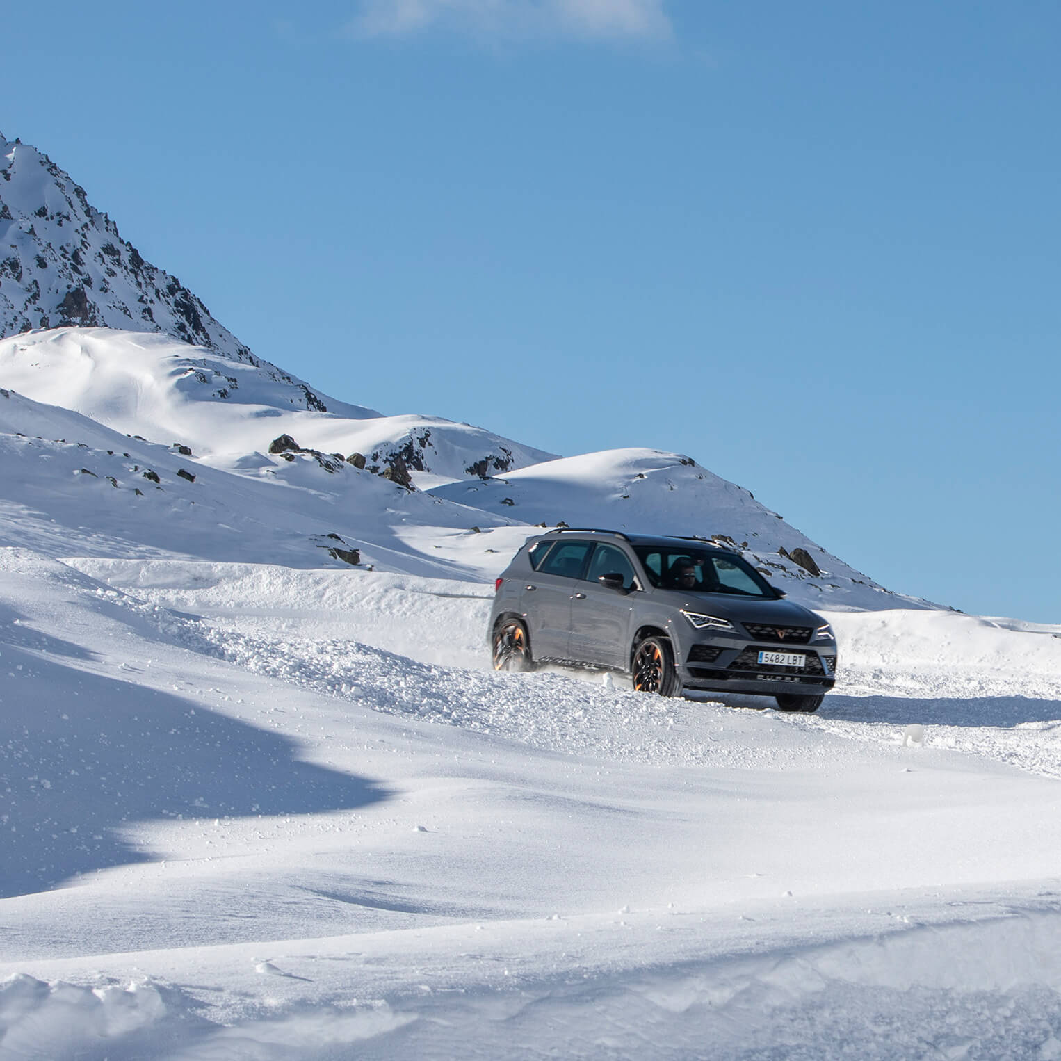 A CUPRA Ateca driving down a snowy mountain