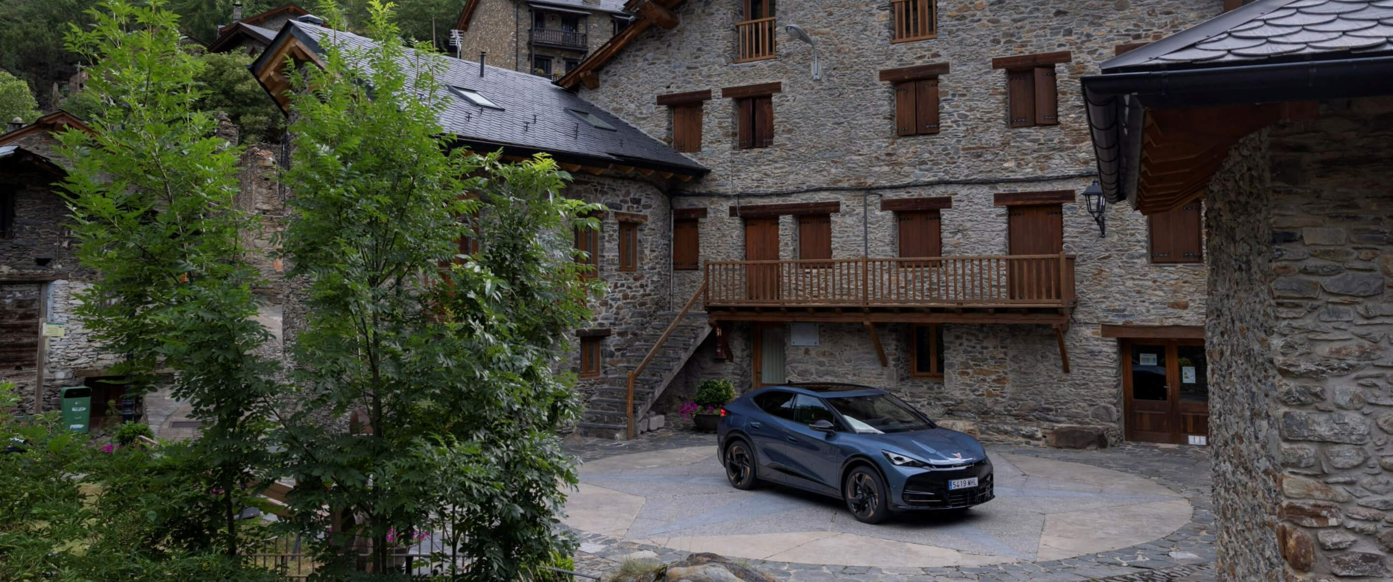 CUPRA Tavascan parked outside a mountain chalet