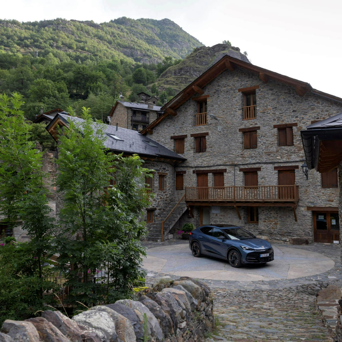 CUPRA Tavascan parked outside a mountain chalet