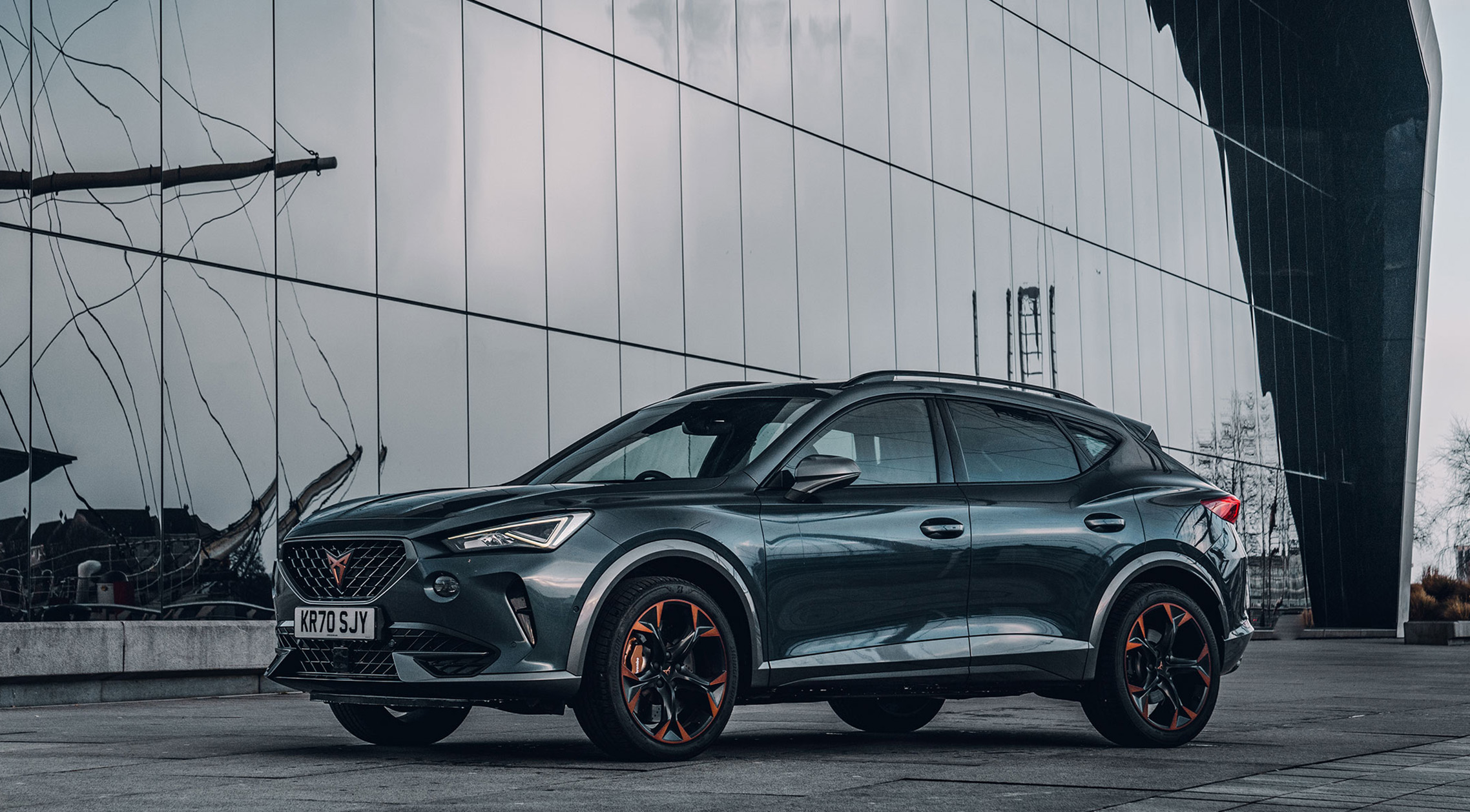 Side shot of a CUPRA Formentor next to a large window