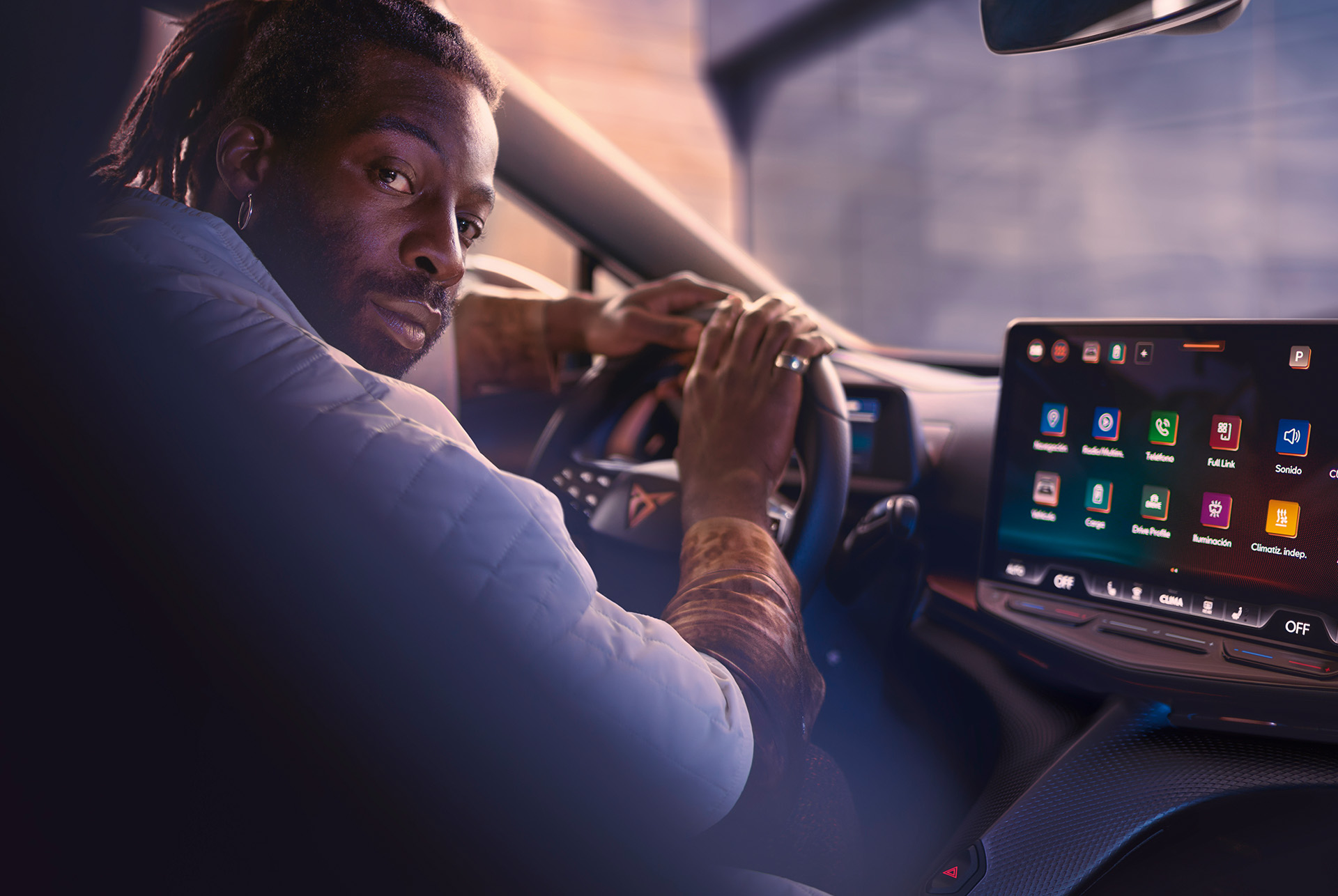 Man behind the steering wheel of a CUPRA Tavascan, with digital display