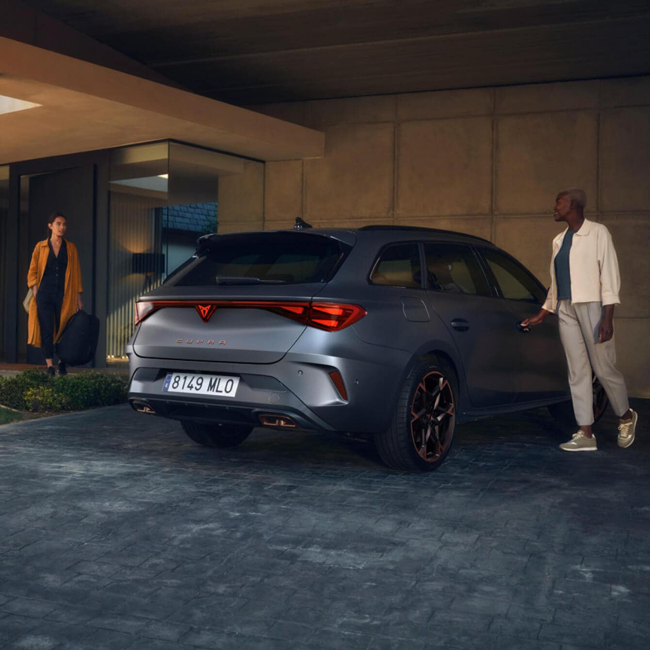 Business colleagues standing next to their CUPRA Formentor parked next to an office