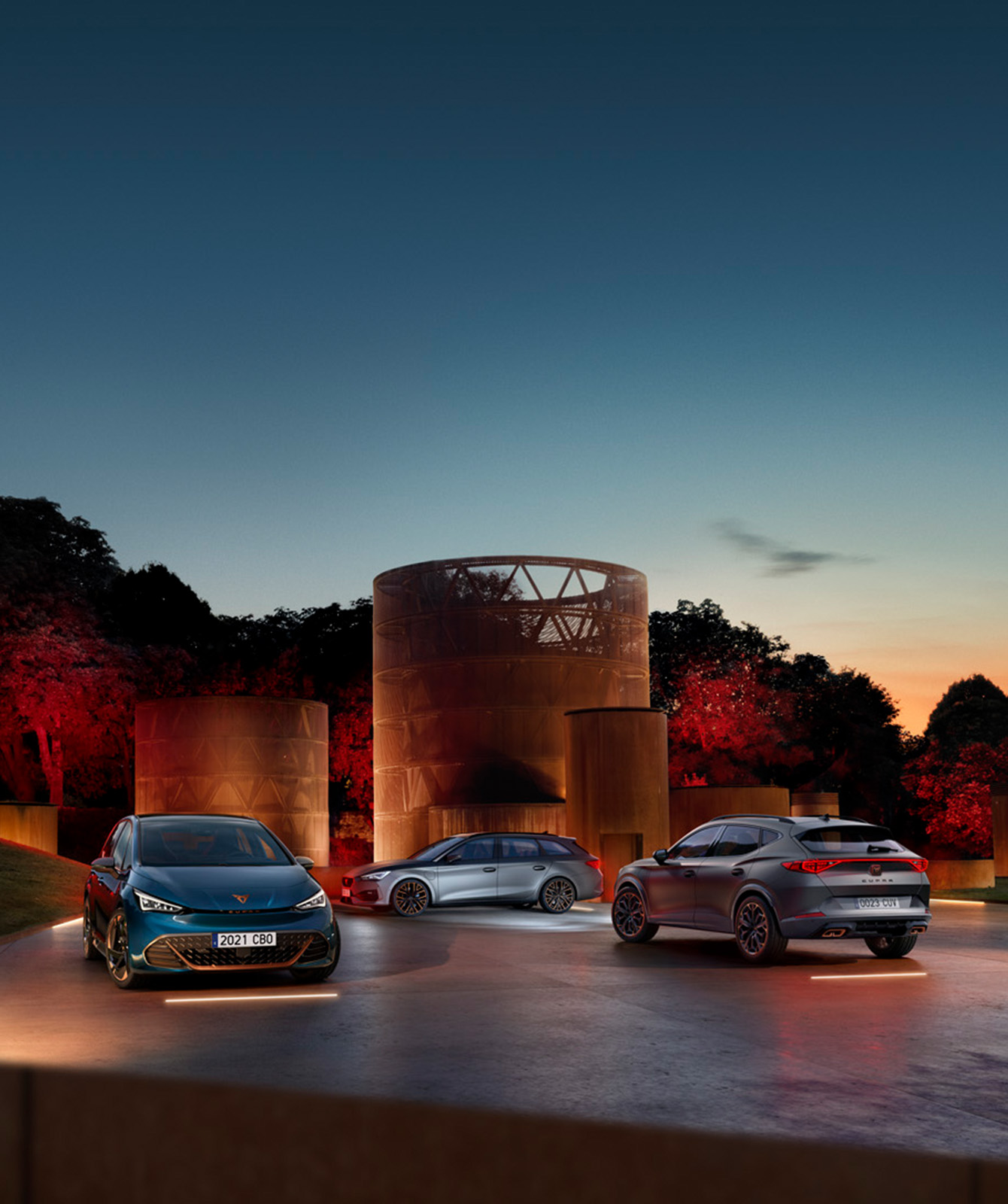 A range of CUPRAs in a scenic area at night