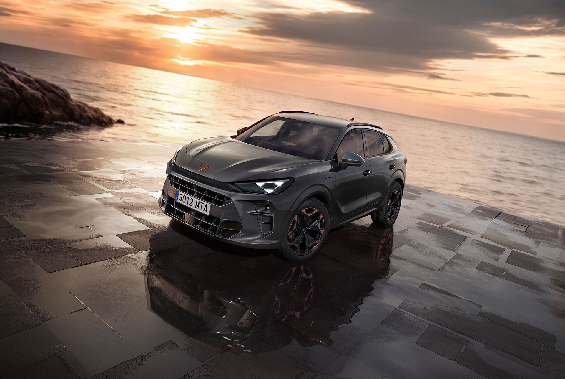 front view of cupra terramar parked by the coast at sunset, featuring led headlamps, timanfaya grey color and 19" cosmic copper wheels. 